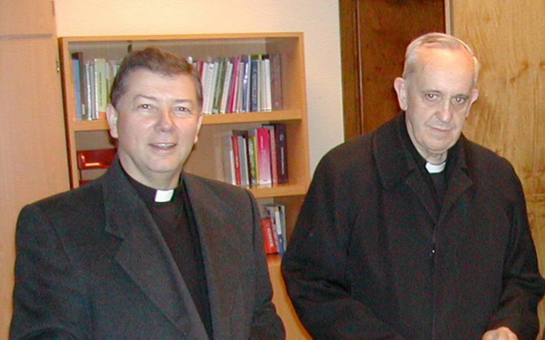 El cardenal Bergoglio (derecha), con monseñor Martínez Camino, en enero de 2006. Tienen en la mano la recién publicada encíclica 'Deus caritas est'