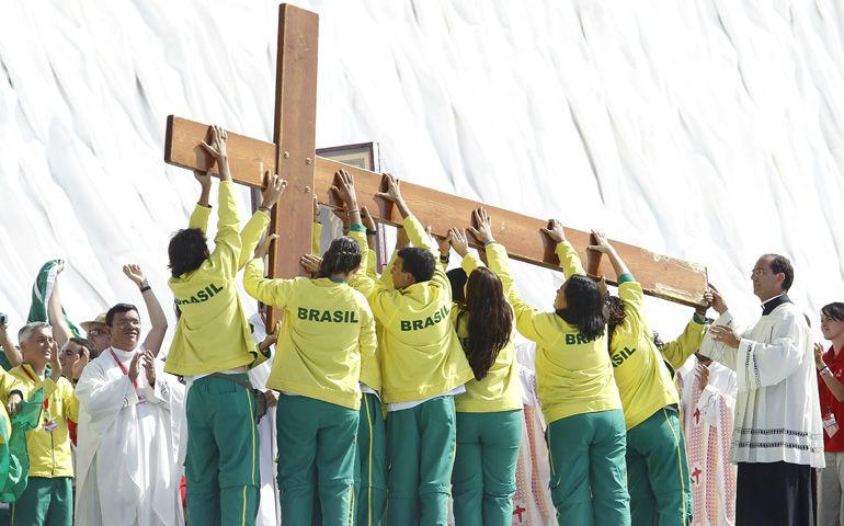 Varios jóvenes de Brasil con la cruz de la JMJ en Cuatro Vientos el 21 de agosto de 2011
