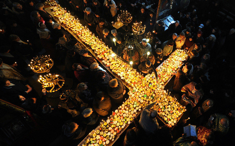 Cada laico es, en su vida diaria, lo que las velas a esta cruz. Todos ellos conforman la Iglesia en el mundo