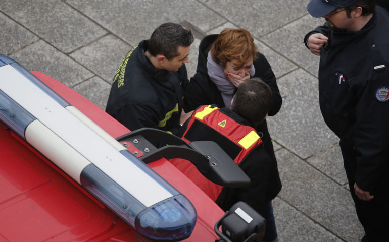 Los bomberos atienden a una mujer tras el atentado contra el semanario 'Charlie Hebdo'