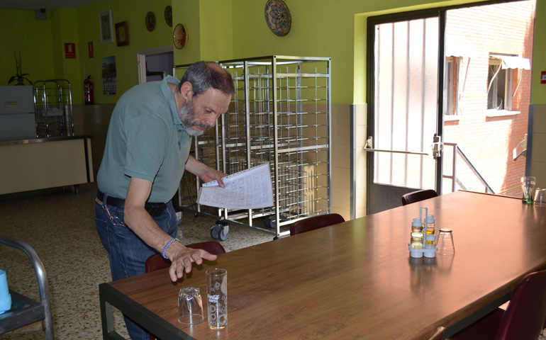 Antonio coloca las mesas en su turno del comedor