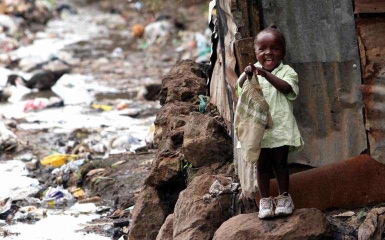 Una niña de tres años juega en un vertedero de Kibera, un barrio de Nairobi, en Kenia.