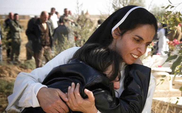 Una religiosa dominica abraza a una joven cristiana cuyo padre ha sido asesinado en Irak.