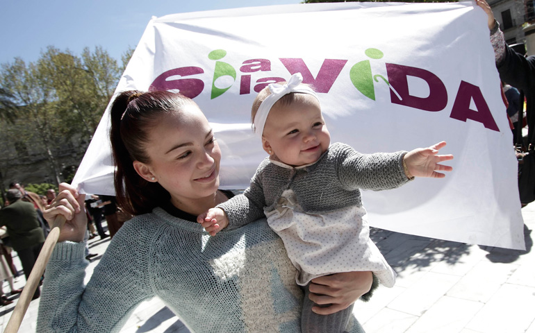 Una mujer con su hija en una concentración por la vida el 23 de marzo de 2014 en Sevilla