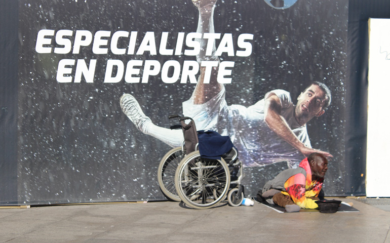 Jadel pide limosna frente a un cartel publicitario de Sol