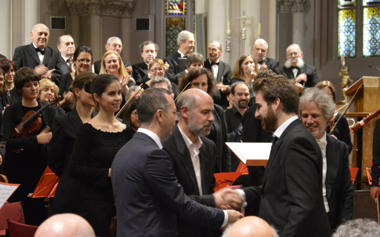 Sebastián Mariné y los dos finalistas que han recibido mención de honor, Francisco Gil a la izquierda de la foto y Juan de Dios Ramírez a la derecha, felicitándose mutuamente, junto a Ignacio Yepes y el coro y la orquesta que interpretaron las obras.