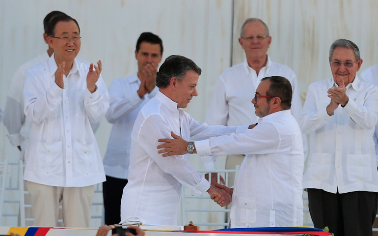 El presidente de Colombia, Juan Manuel Santos, y el líder de las FARC, Rodrigo Londoño 'Timoshenko', se saludan el lunes tras firmar el acuerdo de paz