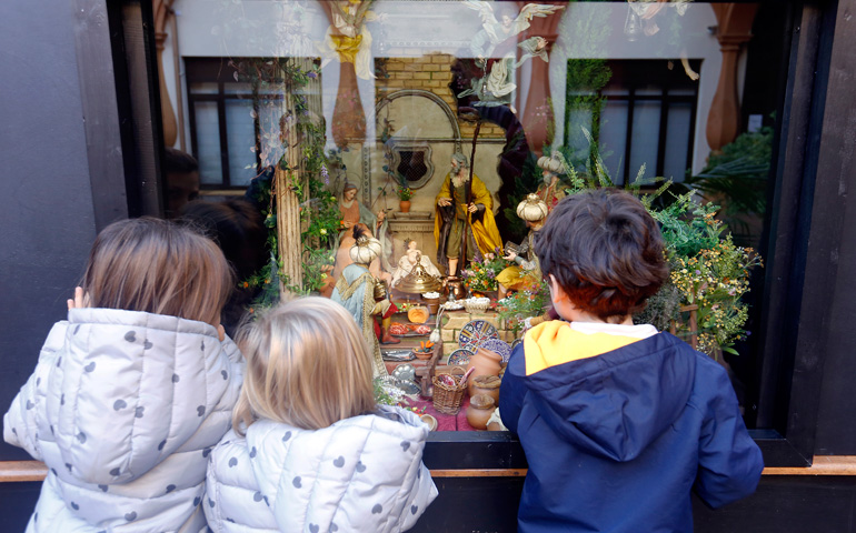 Niños contemplado un belén en un escaparate