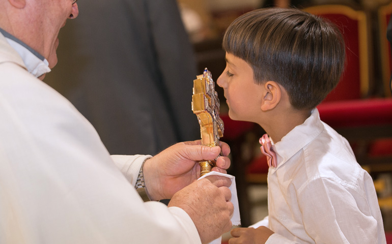Un niño besa el 'Lignum Crucis