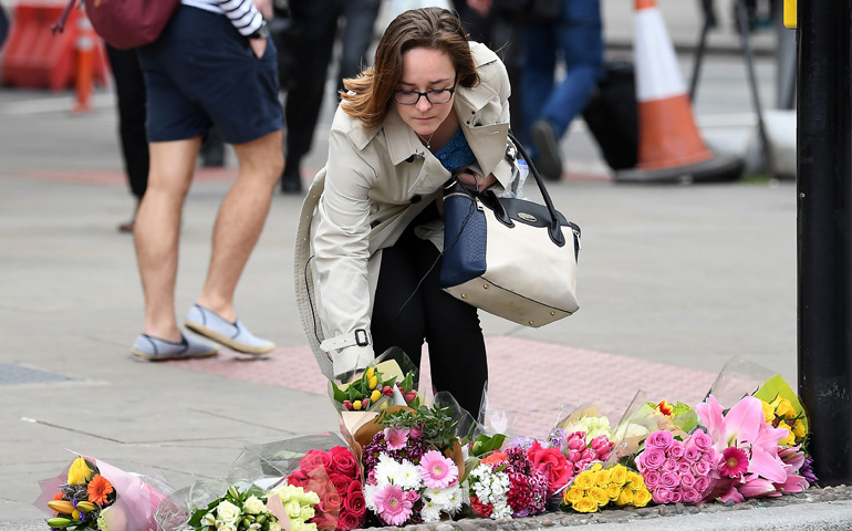 Una mujer deja flores en el lugar del atentado