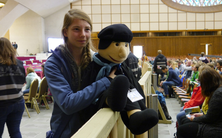 Una joven espera al Papa Francisco con un muñeco de Lutero en el Aula Pablo VI.