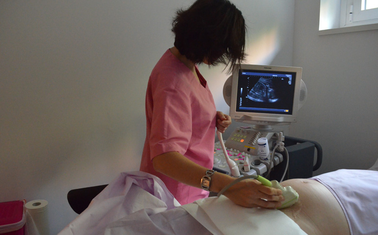 La doctora Marcos realiza una ecografía a la hija de Lucía y Luis durante una consulta de seguimiento