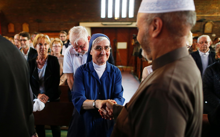 Una monja saluda a un musulmán, durante la celebración de una Eucaristía en la iglesia de Saint-Etienne-du-Rouvray, Francia, el 30 de julio de 2016