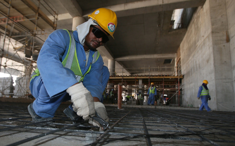 Un trabajador inmigrante durante su jornada laboral en la construcción de una instalación deportiva en Catar