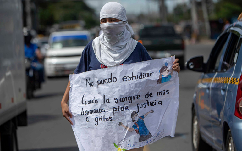 Una joven se manifiesta contra el Gobierno ante la sede de la UCA