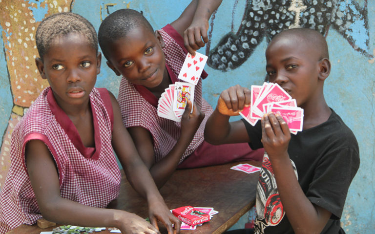 Unos chicos del Centro de Cuidado a Niños juegan a las cartas en la sede de Don Bosco Fambul