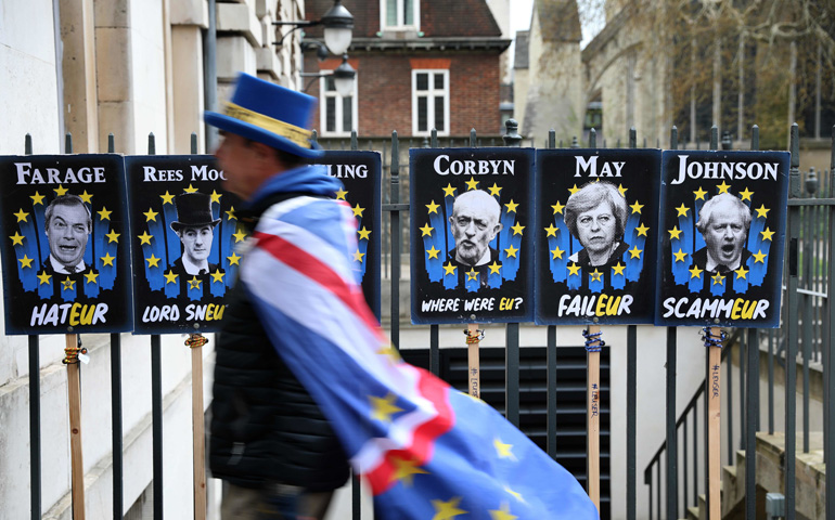 Un manifestante anti-Brexit pasea delante de una serie de pancartas críticas con casi todos los políticos británicos