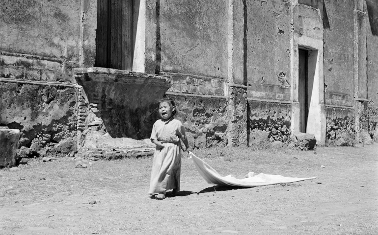 Una niña atraviesa un pueblo devastado por la peste