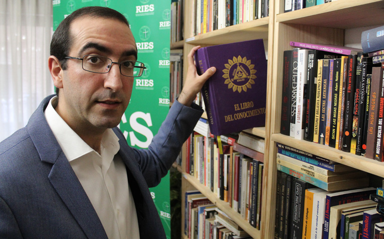 El sacerdote Luis Santamaría en la biblioteca de la Red Iberoamericana de Estudios de las Sectas junto a 'El libro del conocimiento'