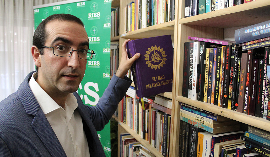 El sacerdote Luis Santamaría en la biblioteca de la Red Iberoamericana de Estudios de las Sectas junto a 'El libro del conocimiento'