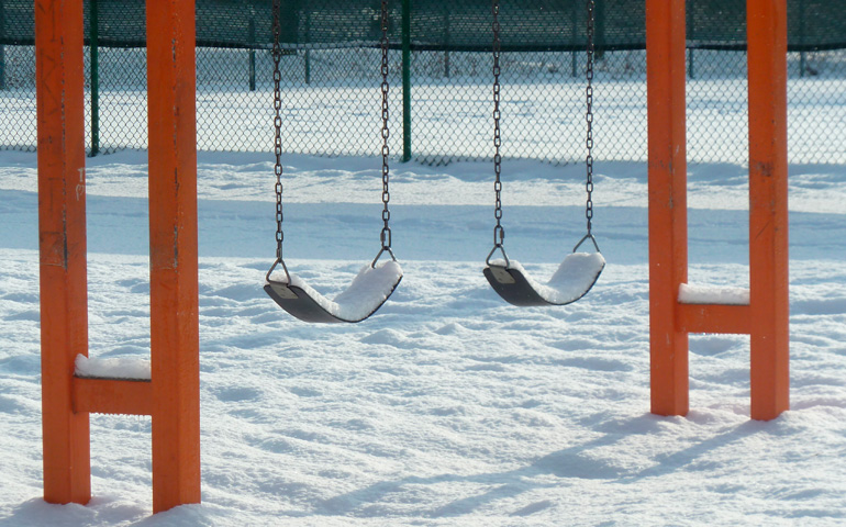 Foto de recurso de un columpio vacío bajo la nieve