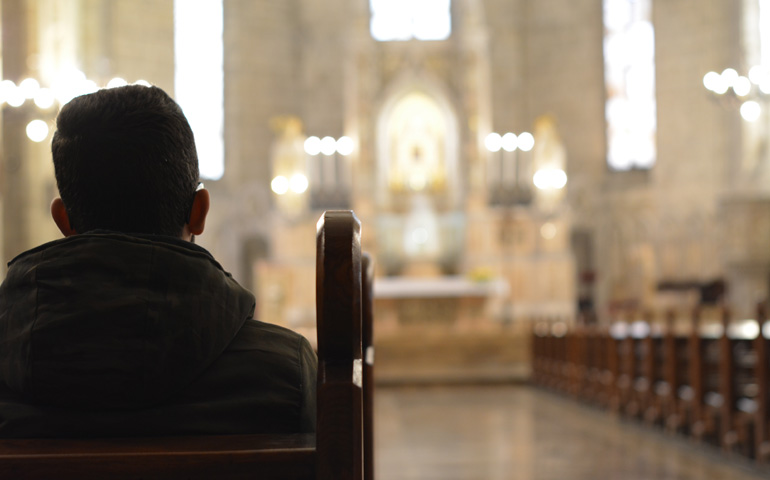 Imagen de recurso de un hombre sentado en el banco de una iglesia