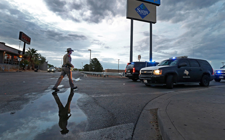 Un agente de las fuerzas de seguridad de Texas regresa a su vehículo, que bloquea una carretera, mientras continúa, este domingo, la investigación del tiroteo masivo perpetrado en un Walmart en El Paso, Texas (Estados Unidos). El tiroteo registrado este sábado dejó al menos 20 muertos y 26 heridos