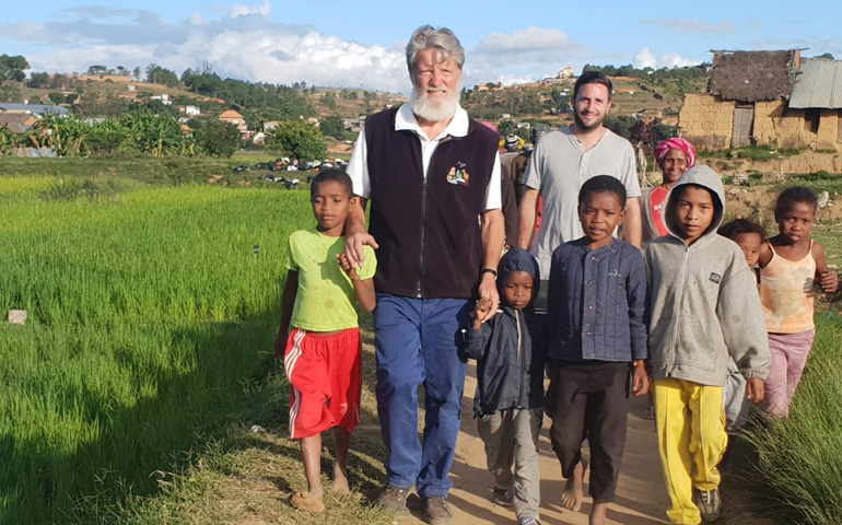 El padre Pedro Pablo Opeka y Gastón Vigo, con un grupo de niños de Akamasoa