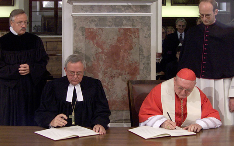 El obispo luterano de Alemania, Christian Krause, Presidente de la Federación Mundial Luterana, y el cardenal Edward Cassidy, presidente del Consejo Pontificio para promoción de la unidad de los cristianos, firmando la declaración conjunta sobre la Doctrina de la Justificación