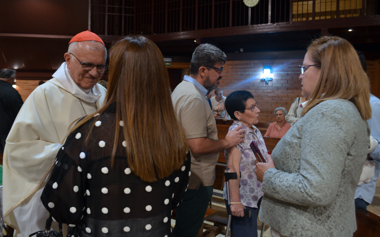 El cardenal Porras saluda a dos venezolanas residentes en Madrid en la parroquia Santa María de la Caridad