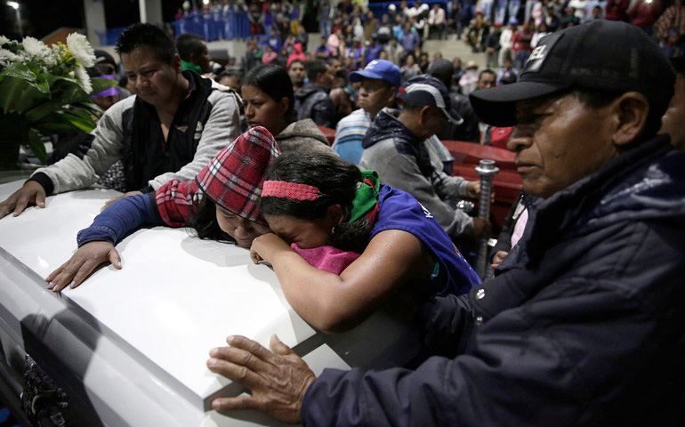 Familiares y amigos de uno de los cuatro guardias indígenas asesinados asisten al sepelio junto a su féretro, el 31 de octubre 2019 en Tacueyó, departamento del Cauca, Colombia