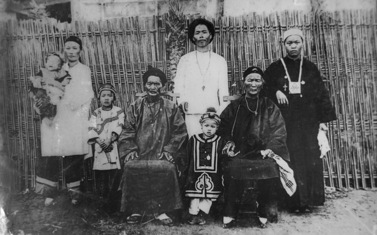 Una familia cristiana de la misión taiwanesa de Bujianglun, con cruces (la señora de la derecha lleva un escapulario) sobre sus vestiduras típicas