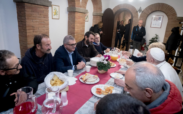 El Papa Francisco comparte una comida con Silvano (segundo por la izquierda), sentado junto al voluntario Carlo Santoro (tercero) y Alessandro (cuarto), en el palacio Migliori durante su inauguración
