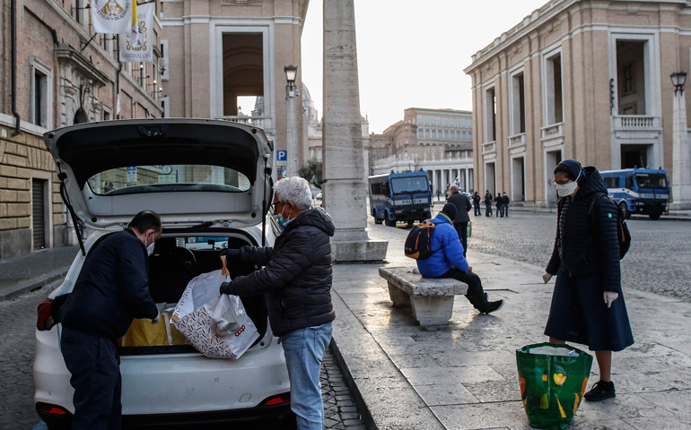 Voluntarios y una religiosa vicenciana sacan alimentos del coche, para repartir entre los más necesitados, en los alrededores de la plaza de San Pedro del Vaticano