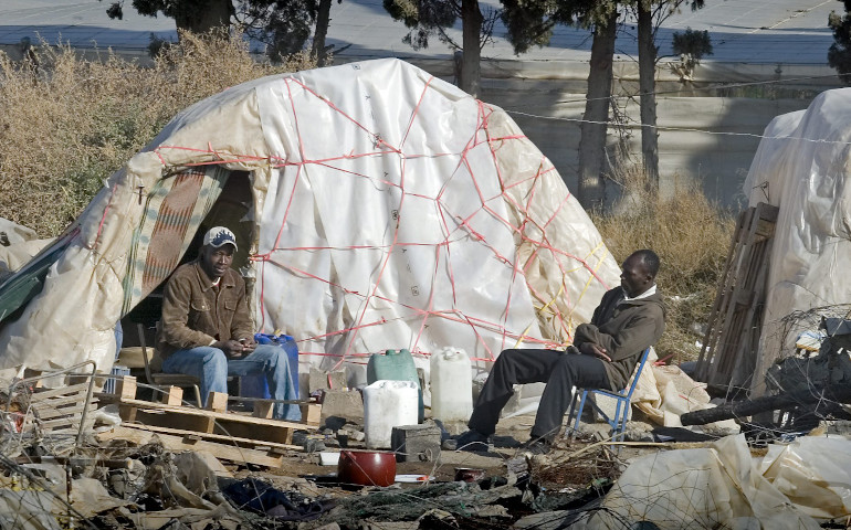 Dos inmigrantes en el exterior de las chabolas en las que viven en Almería