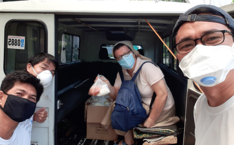 La misionera Gloria Alonso con unos voluntarios durante el reparto de comida