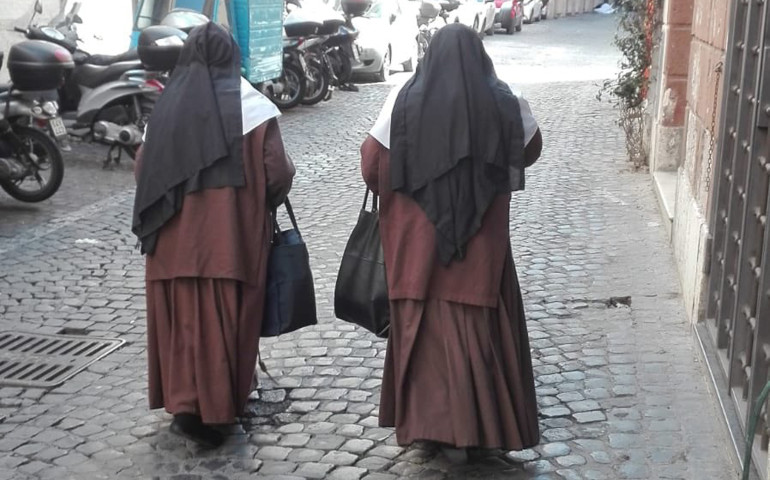 Dos hermanas de la Cruz en una calle de Roma, de camino a casa de un anciano