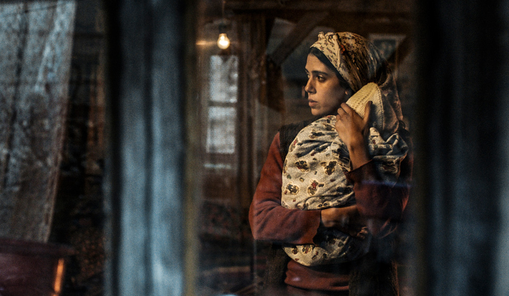 Una de las tres hermanas protagonistas con el bebé al que cuida