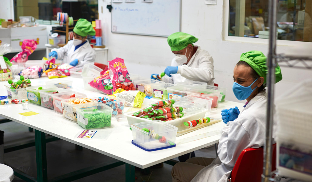 Unas personas con discapacidad intelectual, en el taller de dulces y golosinas, en la sede de la Fundación Alapar, de Madrid, España, el 3 de diciembre de 2020