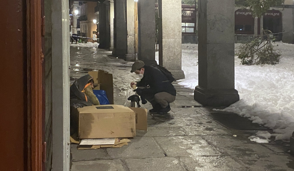 Busto con una persona sin hogar en la plaza Mayor
