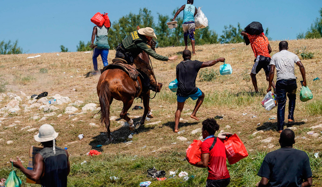 Un agente fronterizo estadounidense intenta detener a inmigrantes haitianos cerca del puente internacional Acuña del Río, en Texas