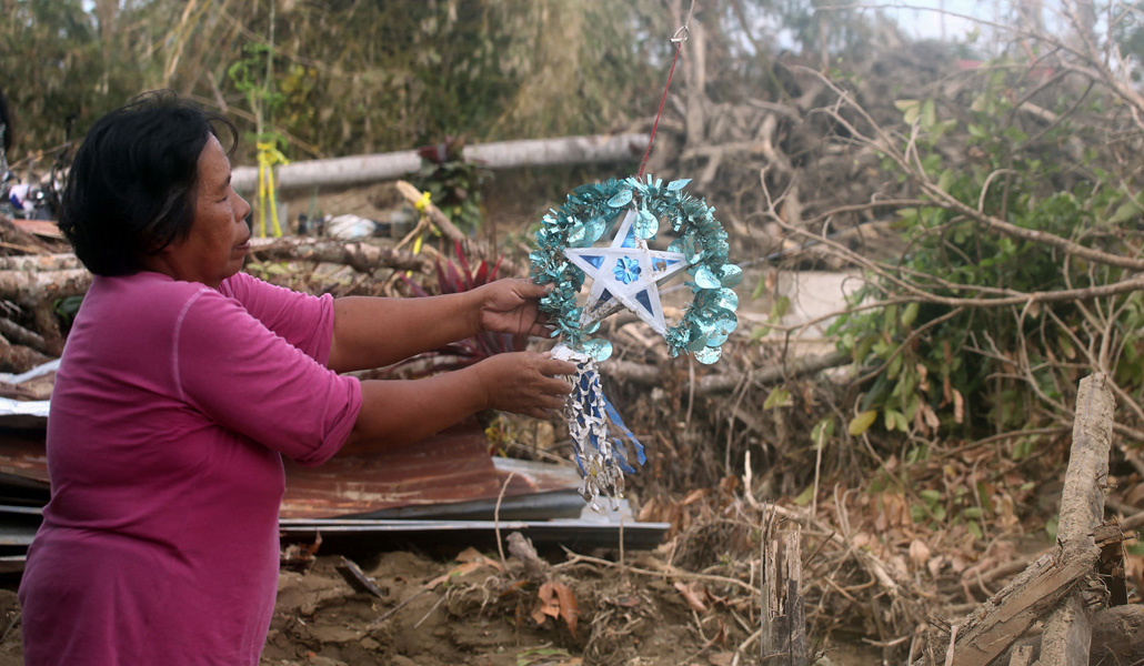 Una mujer cuelga un adorno en las ruinas de su casa, en Bohol. Odette golpeó el día que empezaba Simbang Gabi, la novena de Navidad