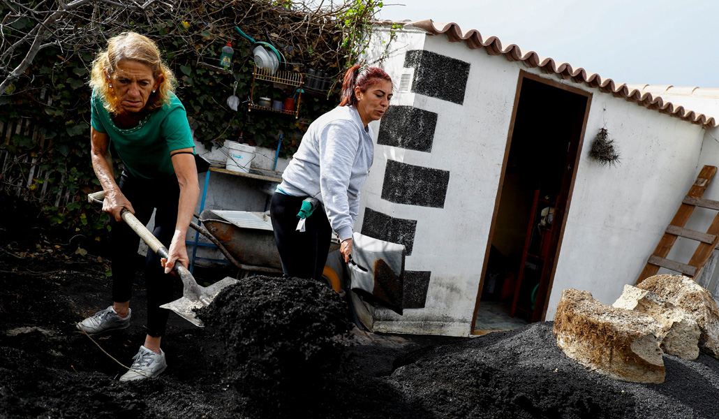 Dos residentes de Las Manchas limpian las cenizas del volcán Cumbre Vieja tras regresar a su casa este jueves