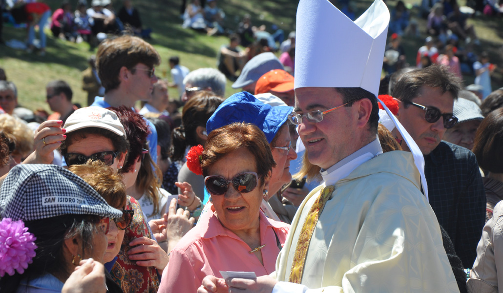 Santos Montoya reparte unas estampas en la pradera de San Isidro, el 15 de mayo de 2018