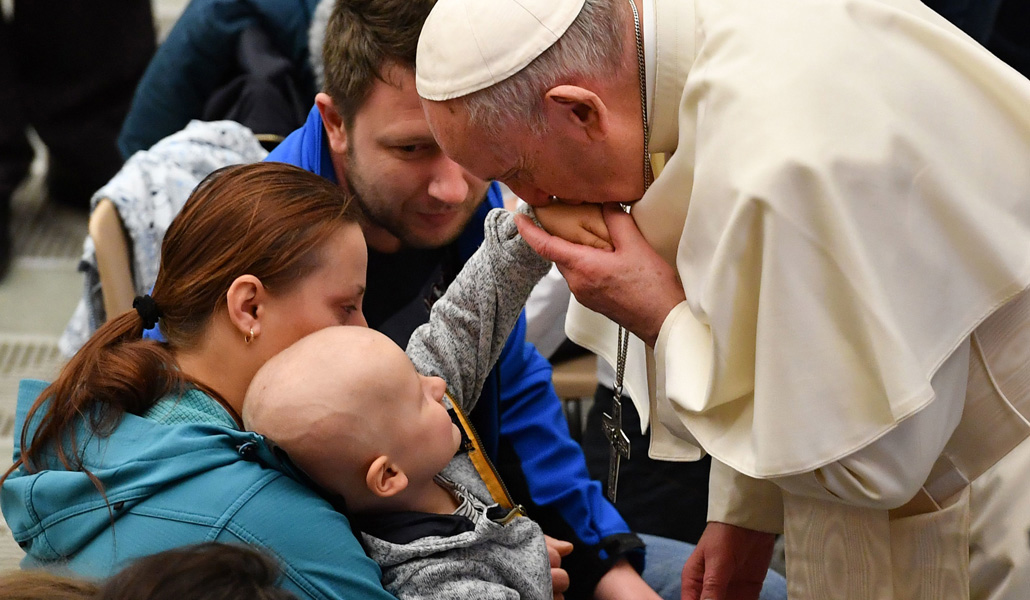 El Papa Francisco bendice a un niño enfermo, durante una audiencia general, en el aula Pablo VI del Vaticano