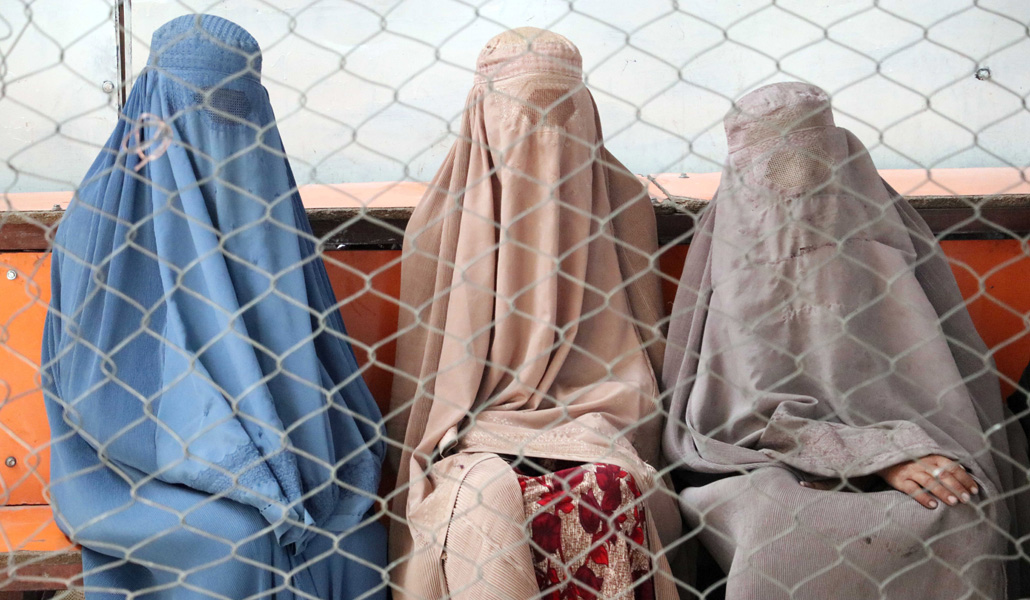 Mujeres con burka esperan para recibir ayuda en un programa de alimentos