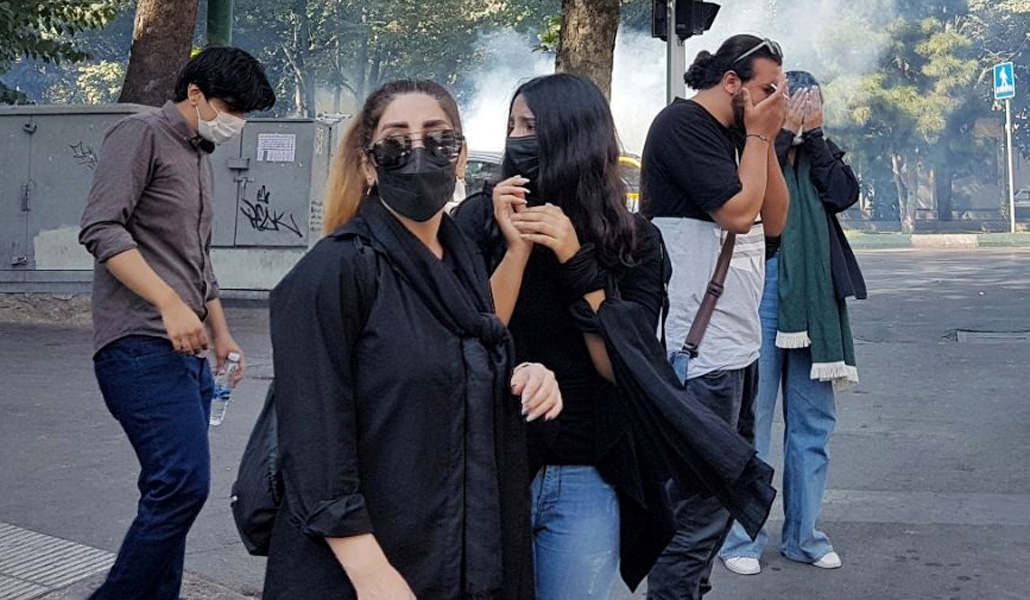 Manifestantes huyen en Teherán, el sábado, después de que la Policía usara gas lacrimógeno