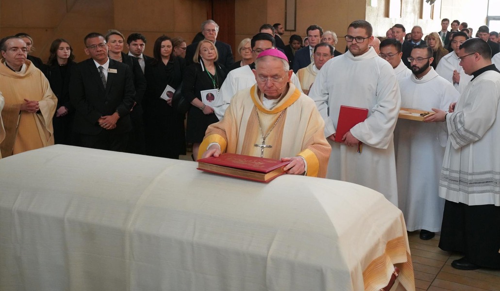 El arzobispo de Los Angeles José H. Gómez coloca el Evangelio y la cruz sobre el féretro de David O'Connell durante el funeral