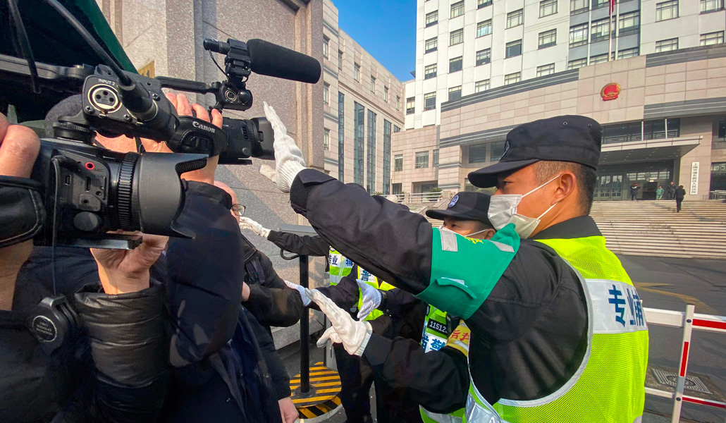 Un policía tapa una cámara de televisión en Shanghái durante el juicio contra el periodista ciudadano chino Zhang Zhan, en diciembre de 2020