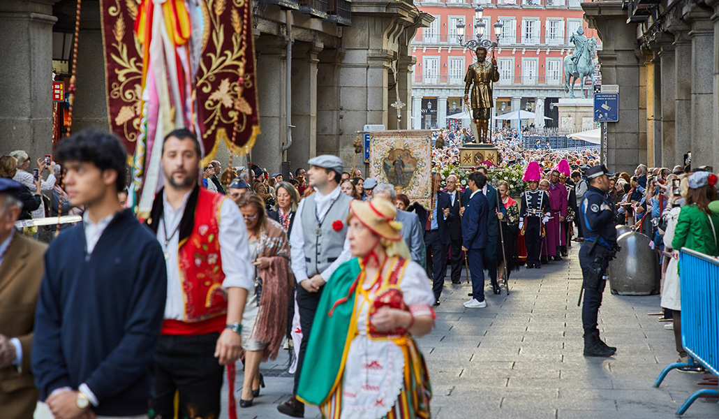Devotos del patrón de Madrid acompañan al santo en procesión a su paso por la Plaza Mayor.